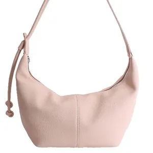 Pink crescent shoulder bag with lychee texture and knotted strap detail on white background