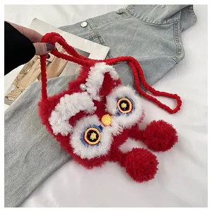 Detail of red knit lion dance bag featuring plush texture and woven shoulder strap