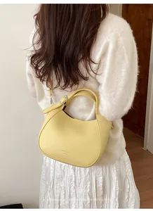 Détail de la texture en cuir jaune clair à motif litchi et du logo de la marque