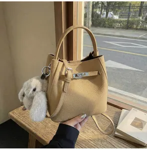 Dettaglio della borsa a secchiello in pelle kaki con ciondolo a forma di coniglietto