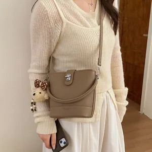 Brown litchi grain bucket bag with silver twist lock and cute bear charm pendant