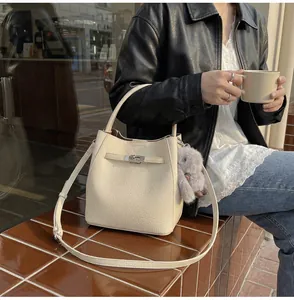 Dettaglio della borsa a secchiello in pelle beige con chiusura in metallo e coniglio