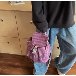 Close-up of purple checkered mini backpack with buckle closure and flap pockets