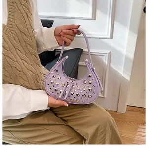 Close-up of lavender crescent shoulder bag with silver studs and smooth faux leather