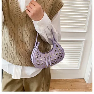 Close-up of lavender crescent bag with silver stud accents and smooth leather texture