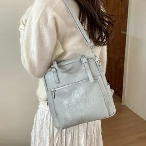 Schicker hellgrauer Kunstleder Rucksack mit geprägten Buchstaben für den Alltag