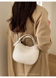 Détail du sac seau en cuir grainé blanc montrant la texture et les ferrures argent