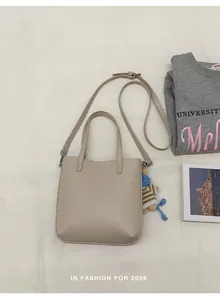 Vue à plat du sac seau crème en cuir grainé avec des finitions en métal argenté