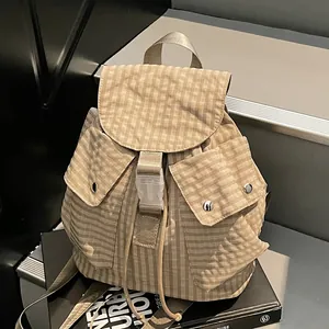 Minimalist beige checkered backpack with buckle closure and dual front pockets for travel