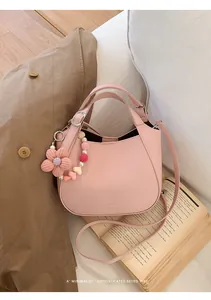Sac seau en cuir rose grainé avec breloque fleurie sur un fond de style de vie doux