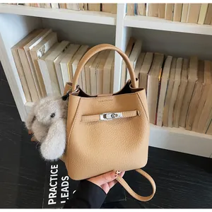 Dettaglio borsa a secchiello in pelle martellata marrone chiaro con chiusura argento e charm
