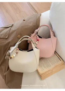 Détail de sacs seaux en cuir grainé souple avec breloques perlées en forme de coeur