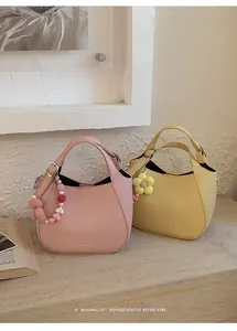 Vue détaillée de mini sacs seaux en cuir grainé rose et jaune avec breloques florales