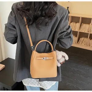Dettaglio della borsa a secchiello in pelle martellata giallo zenzero con chiusura argento