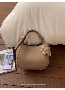 Détail du sac seau en cuir grainé kaki avec fleur tissée et breloque en perle