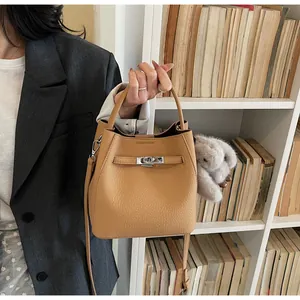 Dettaglio della borsa a secchiello color cammello con fibbia argentata e ciondolo a coniglio