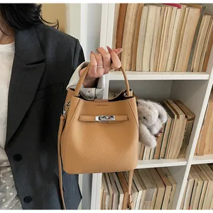 Dettaglio borsa a secchiello in pelle martellata marrone con chiusura argento e charm
