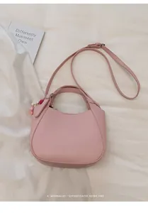 Vue de dessus du sac seau en cuir grainé rose avec charme décoratif sur tissu souple