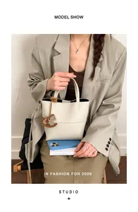 Détail du sac cabas en cuir litchi beige orné d'un pendentif décoratif en forme de cheval