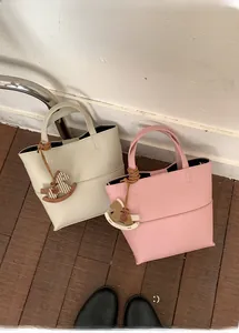 Détail des sacs cabas en cuir grainé avec d'élégants pendentifs en forme de cheval
