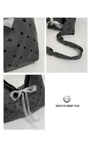 Detail of grey canvas tote bag with black polka dots, lace bow, and knotted strap texture