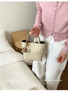 Sac cabas en cuir blanc crème avec logo gaufré et un pendentif cheval à bascule