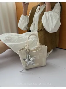 Close-up of vintage bucket bag with checkered pattern and silver starfish charm detail