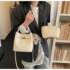 Dettaglio del set borsa a secchiello bianco crema con motivo litchi e chiusura argento