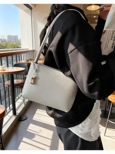 Detail of off-white leather bucket bag with silver chain and capsule pendant
