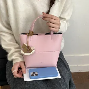 Sac seau en cuir rose à texture litchi avec pendentif cheval et poignée courte