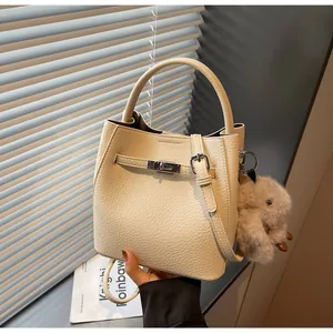 Dettaglio borsa a secchiello in pelle crema con chiusura argento e charm con coniglio