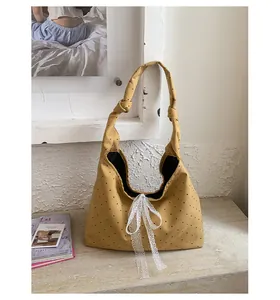 Detail of yellow polka dot canvas tote with lace bow and knotted shoulder strap