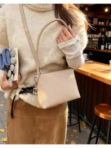 Close-up of beige soft PU leather bucket bag with silver chain and dual straps