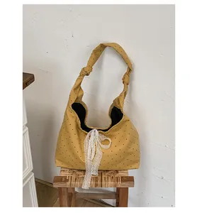 Detail of ginger yellow polka dot canvas tote with lace bow and knotted strap