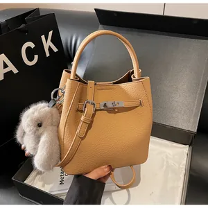 Dettaglio borsa a secchiello in pelle martellata marrone con chiusura argento e charm