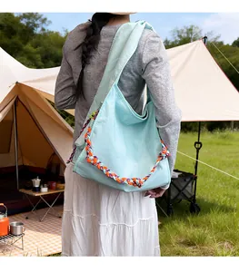 Borsa tote in tela celeste con manico in corda intrecciata colorata in ambiente esterno