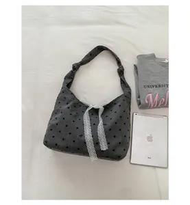 Detailed top view of large grey polka dot canvas tote bag with white lace bow decoration