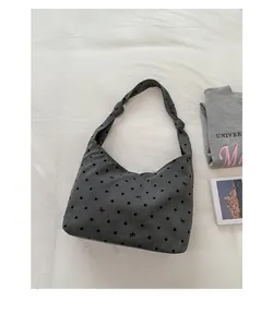 Detail of grey polka dot canvas tote bag with bow patterns and shoulder strap knot