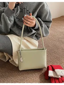 Close-up of smooth light green soft leather bucket bag with silver metal pendant detail