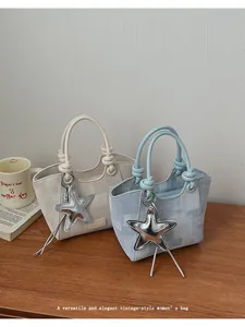 Detail of cream and light blue bucket bags with textured fabric and star pendants