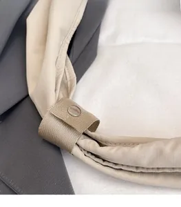 Dettaglio del manico in nylon rinforzato con chiusura a scatto su borsa beige chiaro