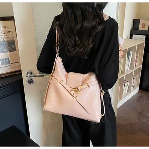 Dettaglio della borsa tote in ecopelle rosa chiaro con cinghie incrociate e fibbia in metallo