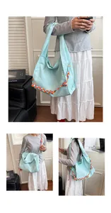 Dettagli della borsa tote in tela azzurra con corde colorate intrecciate decorative