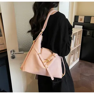 Dettaglio della borsa tote in pelle rosa con fibbie dorate e logo stampato