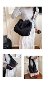 Dettaglio di una grande borsa tote nera con tracolla in tessuto colorato per uso quotidiano