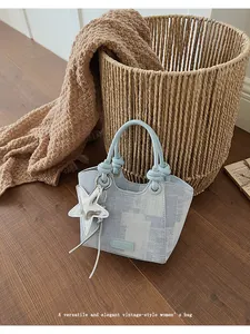 Detail of vintage blue pixel pattern bucket bag with star charm on dark wood floor