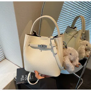 Dettaglio della borsa a secchiello in pelle martell pelle beige con fibbia in metallo e ciondolo a coniglio