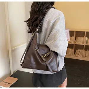 Dettaglio della borsa tote in pelle PU marrone scuro con fibbia dorata su modella