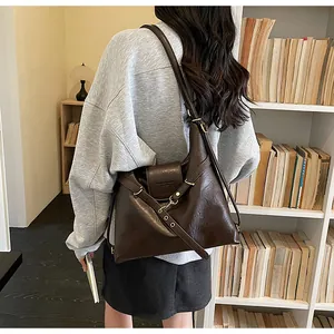 Dettaglio della grande borsa tote marrone scuro indossata a tracolla per donna