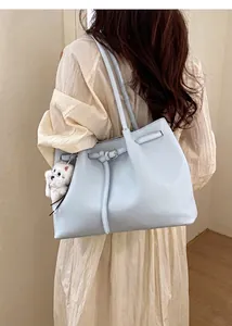 Hellblaue Shopper-Tasche aus Kunstleder mit Hundeanhänger als Schultertasche getragen